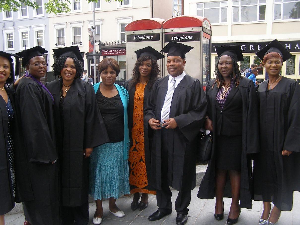 A group of Keyznow graduates in caps and gowns standing together on a London street
