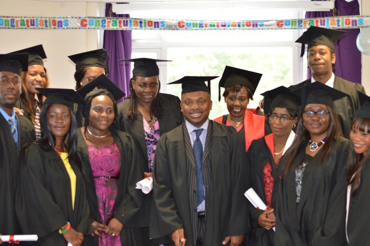 Keyznow graduates celebrating indoors beneath a congratulations banner